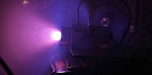 The plasma glow created by Phase Four’s novel RF spacecraft engine firing on AFRL’s “green” propellant.